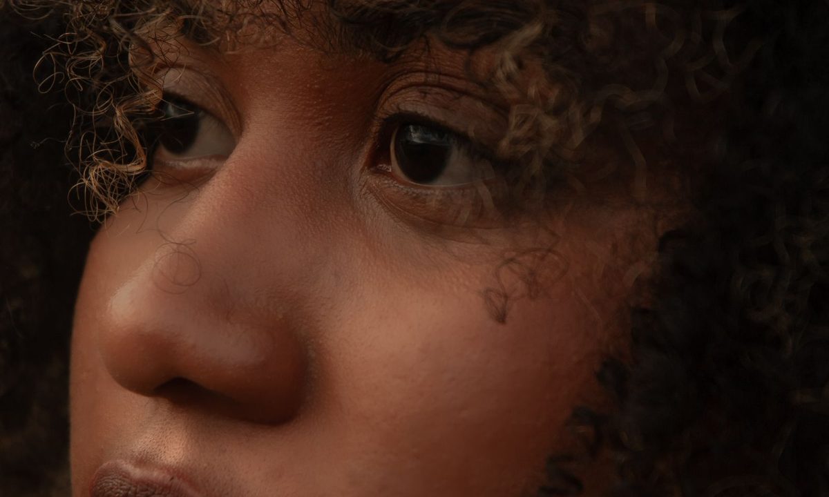 A woman with defined natural curls smiling