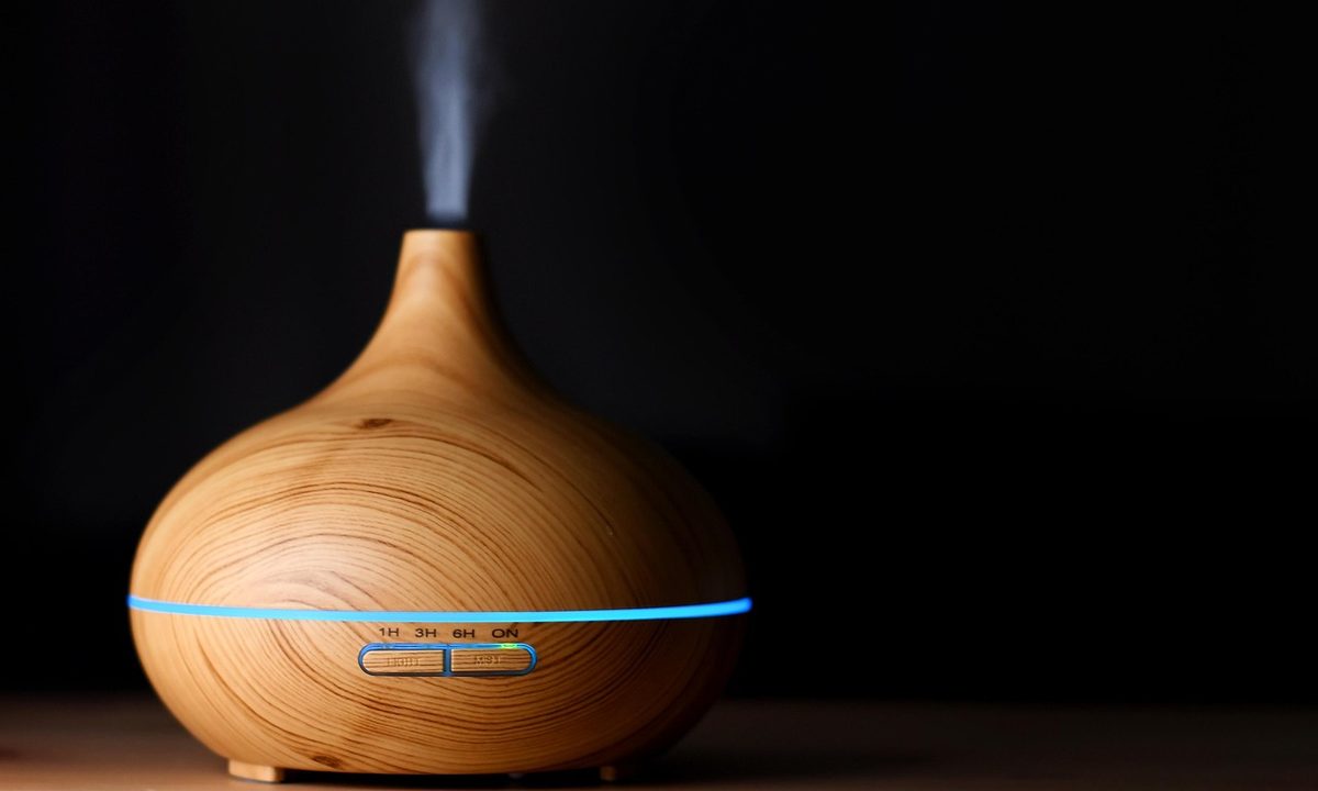 An essential oil diffuser releasing mist in a calm room
