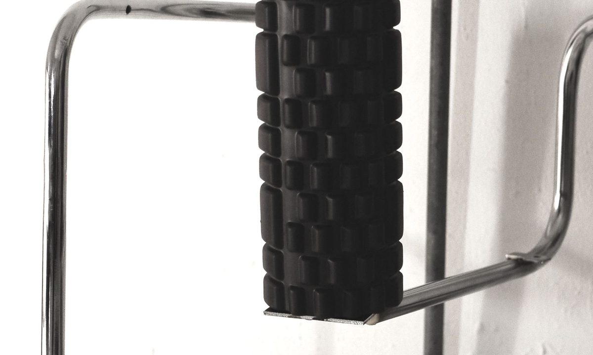 A foam roller on a gym floor during recovery