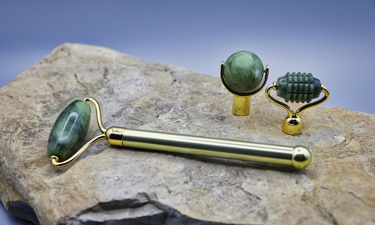 A jade face roller resting on a clean surface
