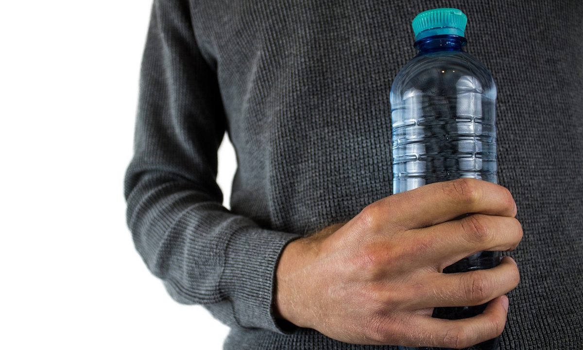A reusable water bottle beside a gym bag