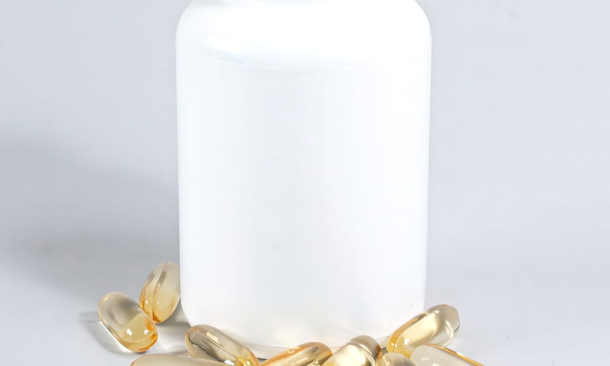 Omega-3 fish oil capsules and a glass of water