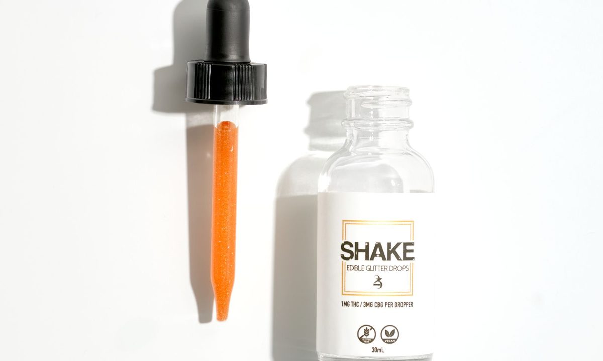 A serum bottle with a dropper on a skincare shelf